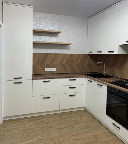 Современная угловая кухня с деревянным фартуком и встроенной техникой